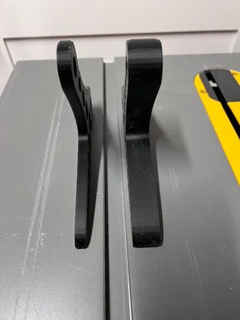 Może przedstawiać: Dwa czarne plastikowe elementy, obok siebie, o nieco innym wzorze. Elementy prawdopodobnie są do projektu druku 3D.