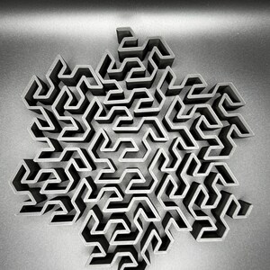 May include: A 3D printed black snowflake design with a complex maze pattern.