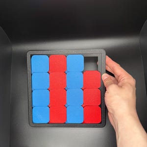 Pu&ograve; includere: Una cornice nera con una griglia di 16 quadrati. I quadrati sono riempiti con blocchi rossi e blu. Un quadrato &egrave; vuoto.
