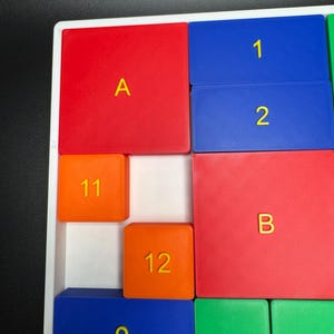 May include: A red, blue, and orange puzzle with numbers and letters. The numbers 1, 2, 9, 11, and 12 are visible. The letters A and B are also visible.