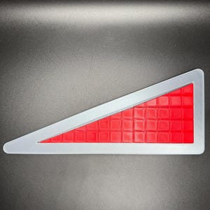 Puede incluir: Una se&ntilde;al de seguridad triangular roja y plateada con un patr&oacute;n de cuadr&iacute;cula.