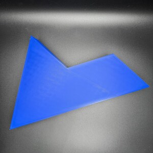 May include: A blue plastic puzzle piece with a unique shape. The piece is made of a smooth, solid plastic and has a bright blue color.