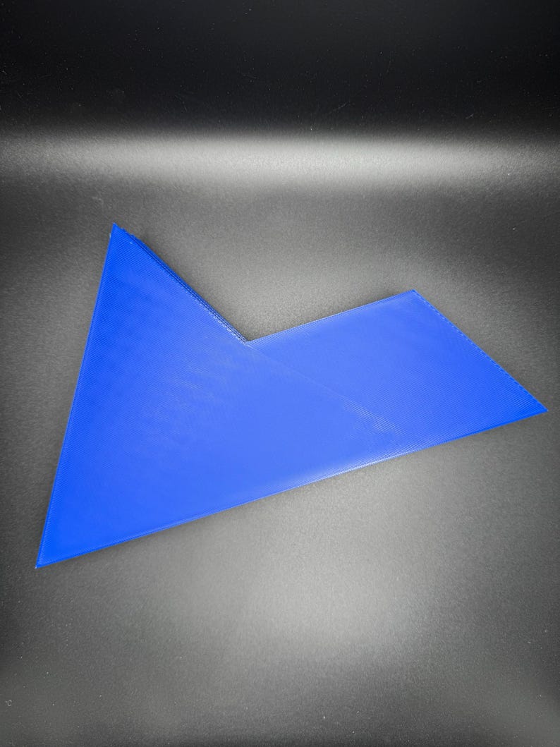 May include: A blue plastic puzzle piece with a unique shape. The piece is made of a smooth, solid plastic and has a bright blue color.