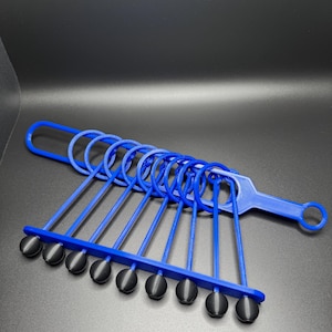 Pode incluir: Um conjunto de an&eacute;is de pl&aacute;stico azul com pontas de borracha preta. Os an&eacute;is s&atilde;o conectados por uma al&ccedil;a de pl&aacute;stico azul.