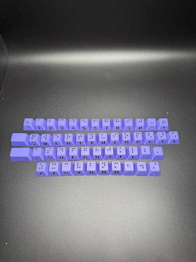 May include: A set of purple keyboard keys with black lettering. The keys include the letters of the alphabet, numbers, and punctuation marks.