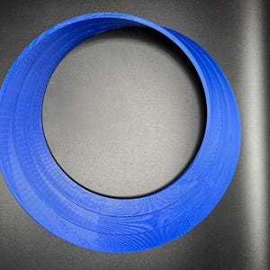 May include: A blue plastic ring with three layers, creating a circular shape.