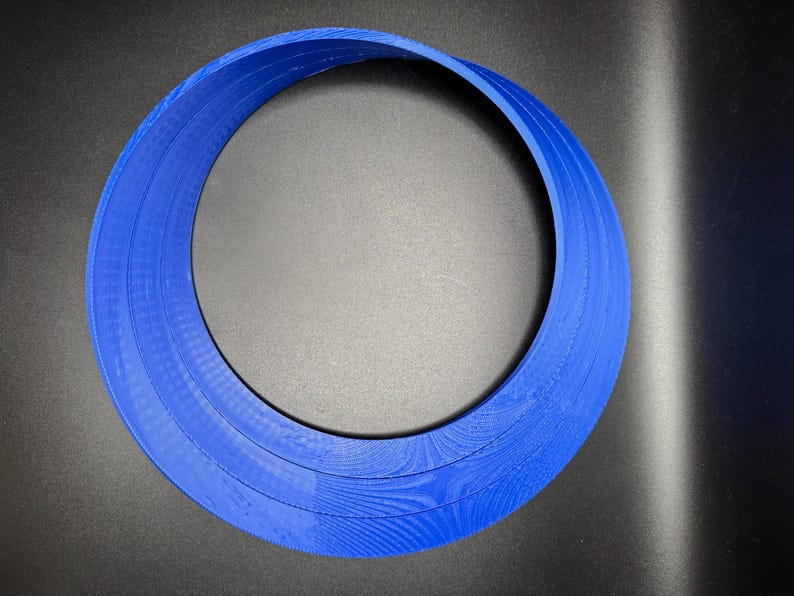 May include: A blue plastic ring with three layers, creating a circular shape.