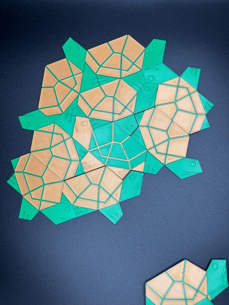 May include: A geometric puzzle made of green and brown plastic pieces. The pieces are shaped like irregular polygons and fit together to form a larger shape.