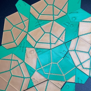 May include: A set of geometric shapes made of 3D printed plastic. The shapes are in shades of green and brown and have a honeycomb pattern.