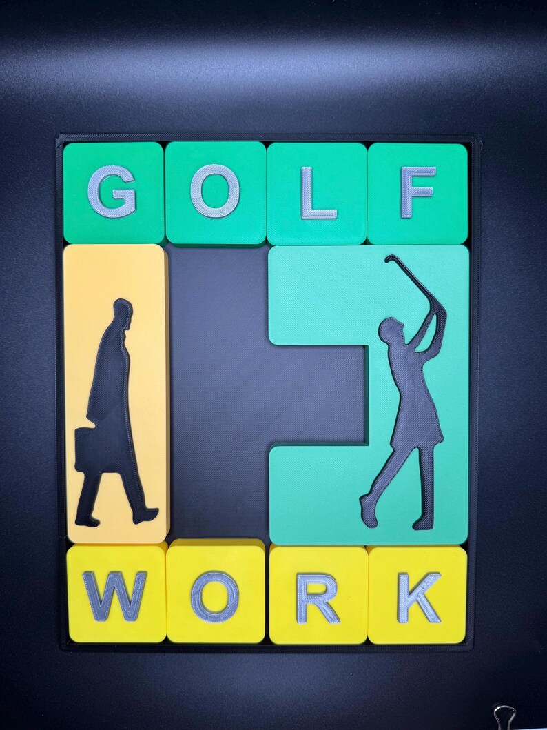 May include: A green and yellow tile puzzle with the word "GOLF" on top and the word "WORK" on the bottom. The puzzle features a silhouette of a person playing golf and a silhouette of a person carrying a briefcase.