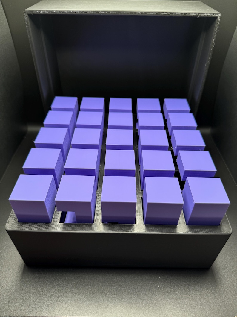 May include: A black box with a lid open, revealing a grid of 25 small, purple cubes.