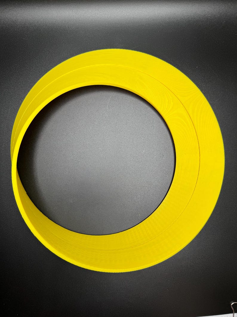 May include: A yellow plastic ring with two concentric circles. The ring is approximately 25 cm in diameter.