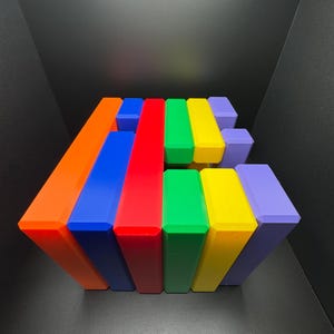 May include: A stack of colorful rectangular blocks in shades of orange, blue, red, green, yellow, and purple. The blocks are arranged in a staggered pattern, creating a visually appealing geometric design.