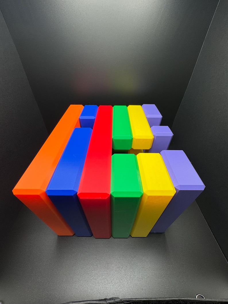 May include: A stack of colorful rectangular blocks in shades of orange, blue, red, green, yellow, and purple. The blocks are arranged in a staggered pattern, creating a visually appealing geometric design.