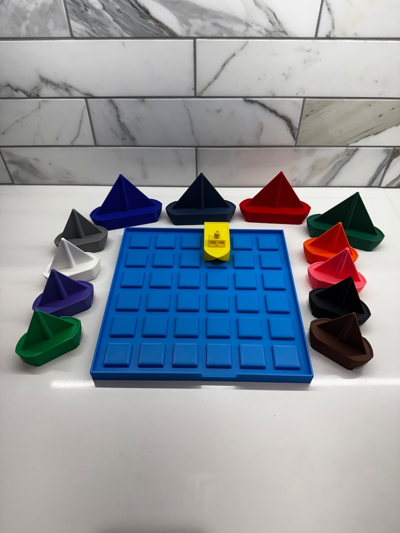 May include: A blue game board with 36 squares and 12 colorful toy sailboats. The sailboats are in various colors, including red, blue, green, white, black, and brown. A yellow toy boat is in the center of the board.