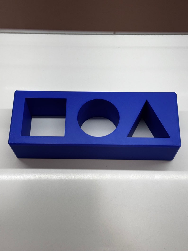May include: A blue plastic block with cutouts of a square, circle, and triangle.