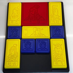 May include: A yellow, red, and blue tile puzzle game with Chinese characters and images of people. The tiles are arranged in a grid pattern and fit into a black frame.