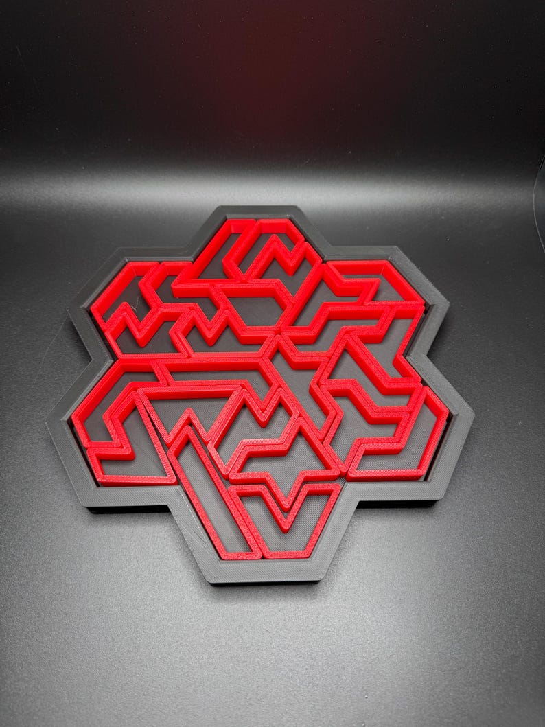 May include: A red 3D printed geometric design with a honeycomb shape. The design is made up of multiple layers of interlocking shapes.
