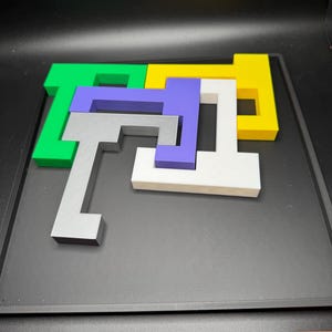 Op de afbeelding: Een puzzel met vijf stukken in verschillende kleuren: groen, geel, wit, paars en grijs. De stukken zijn in een complex patroon op een zwart oppervlak gerangschikt.