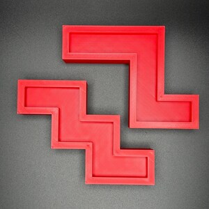 Puede incluir: Dos piezas de rompecabezas de pl&aacute;stico rojo en forma de escalera y L. Las piezas encajan para formar una forma m&aacute;s grande.
