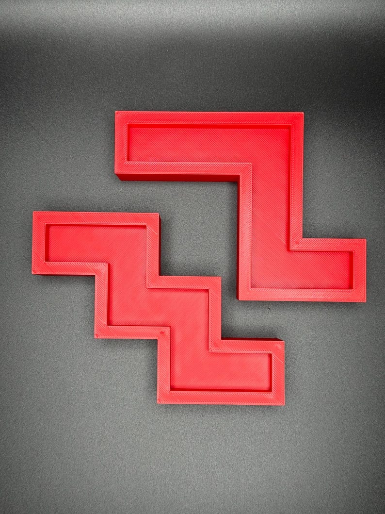 Puede incluir: Dos piezas de rompecabezas de pl&aacute;stico rojo en forma de escalera y L. Las piezas encajan para formar una forma m&aacute;s grande.