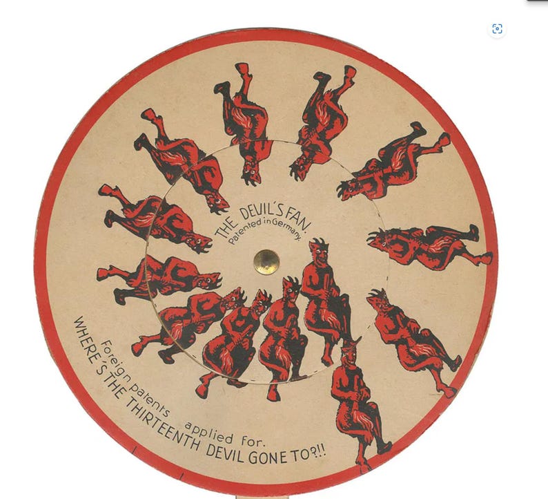 Op de afbeelding: Een vintage optische illusie speelgoed, "The Devil's Fan", met rode duivels in een cirkelvormige opstelling. De tekst bevat "Patented in Germany" en "Where's the Thirteenth Devil Gone To?!!" op een beige achtergrond met een rode rand.