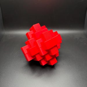 May include: A red 3D puzzle made of interlocking cubes. The puzzle is in the shape of a sphere.