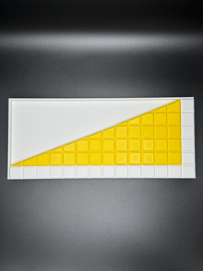 May include: A white tray with a yellow grid pattern in the shape of a triangle. The grid is made up of small squares.