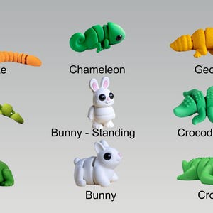 Puede incluir: Un conjunto de nueve juguetes de animales de pl&aacute;stico coloridos y segmentados. Los animales incluyen una serpiente pit&oacute;n, un camale&oacute;n, un gecko, un lagarto, un conejito, un conejito de pie, un cocodrilo, un cocodrilo peque&ntilde;o y una rana.