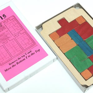 May include: A wooden puzzle game called "Climb 15" with a pink instruction card. The game includes a wooden frame with colorful wooden blocks that need to be moved to solve the puzzle.