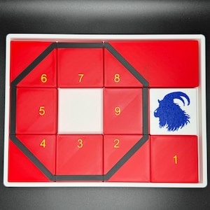 May include: A red and black puzzle with a goat silhouette in the center. The puzzle is numbered 1 through 9.
