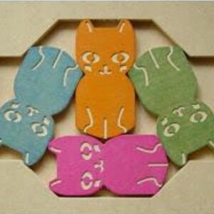 May include: A wooden puzzle featuring six colorful cat-shaped pieces in orange, blue, green, and pink. The puzzle pieces have white facial details and are arranged within a light-colored wooden frame. A fun and engaging toy for children.