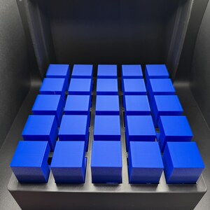 May include: A black storage box with a lid open, revealing a grid of 25 blue cube-shaped containers.