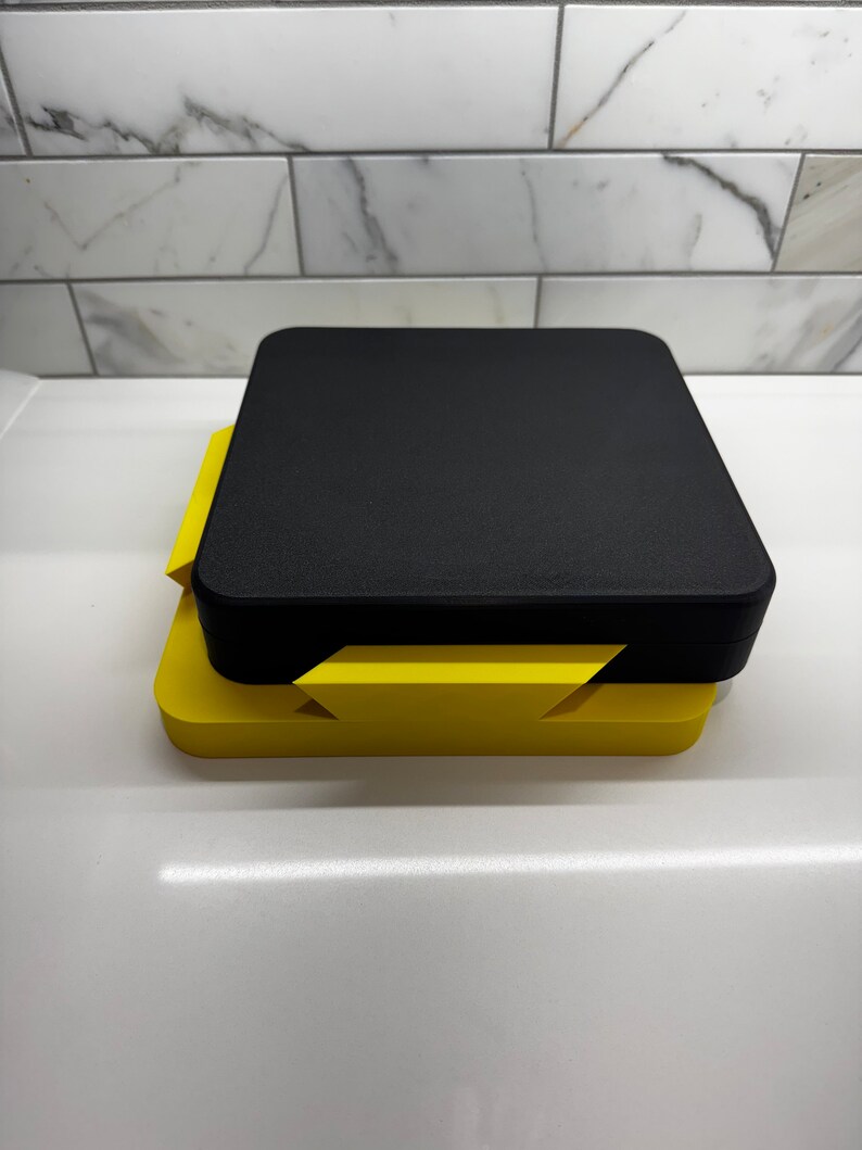 May include: A black and yellow 3D printed box with a lid. The box is made of two pieces that fit together.