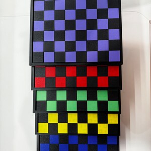 Puede incluir: Un conjunto de siete tableros de ajedrez con marco negro y cuadrados de diferentes colores. Los cuadrados son morados, rojos, verdes, amarillos, azules y naranjas.