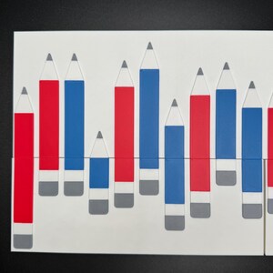 Peut inclure: Un fond blanc avec une rang&eacute;e de crayons rouges et bleus de hauteurs diff&eacute;rentes. Les crayons sont dispos&eacute;s en un motif, les crayons rouges &agrave; gauche et les crayons bleus &agrave; droite.