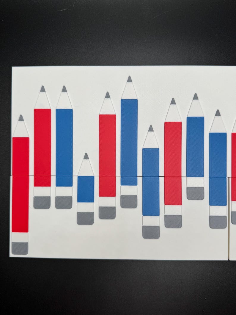 Peut inclure: Un fond blanc avec une rang&eacute;e de crayons rouges et bleus de hauteurs diff&eacute;rentes. Les crayons sont dispos&eacute;s en un motif, les crayons rouges &agrave; gauche et les crayons bleus &agrave; droite.