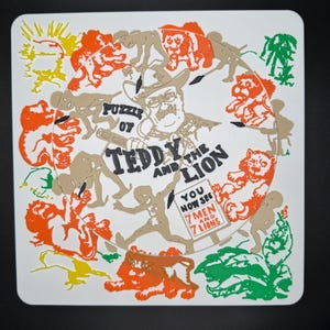 May include: A square, white puzzle featuring a circular design with the text "Puzzle of Teddy and the Lion." The design includes illustrations of lions, men, and the text "You now see 7 men and 7 lions." The puzzle has orange, green, yellow, and tan accents.