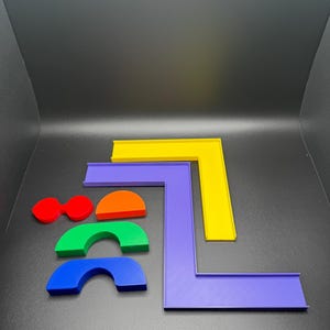 May include: A set of colorful plastic shapes, including a yellow, purple, and orange L-shaped piece, and three rainbow-colored arches.