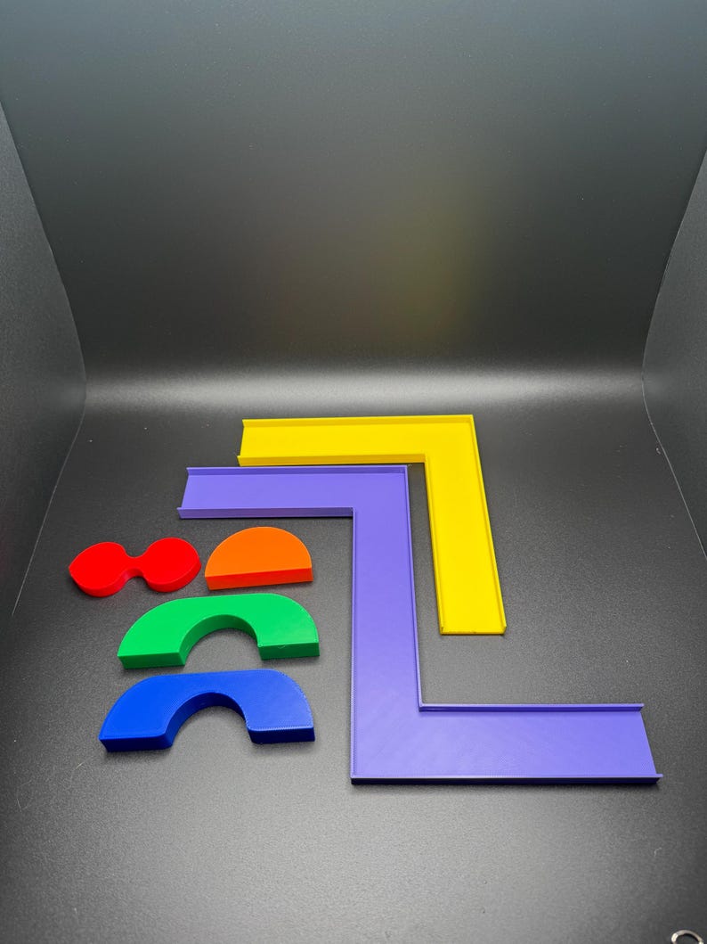 May include: A set of colorful plastic shapes, including a yellow, purple, and orange L-shaped piece, and three rainbow-colored arches.