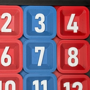 Pu&ograve; includere: Primo piano di un gioco di puzzle di numeri con quadrati rossi e blu. I numeri 2, 3, 4, 6, 7, 8, 10, 11 e 12 sono visibili sui quadrati.