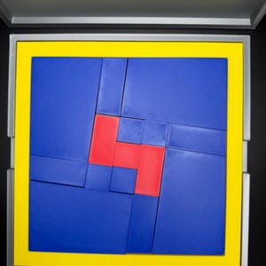 May include: A blue and red puzzle with a yellow border. The puzzle is made up of many small squares that fit together to form a larger square.