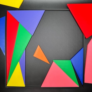 May include: A colorful geometric puzzle with pieces in red, blue, green, yellow, orange, and pink. The pieces are arranged on a black background.