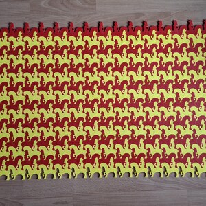 May include: An interlocking puzzle mat featuring a repeating pattern of red and yellow horse silhouettes. The foam mat has a scalloped edge. The design creates a visually engaging surface, suitable for play or decoration.