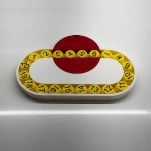 May include: A white plastic circular puzzle with a red center and yellow numbered pieces. The numbers 1 through 20 are displayed on the yellow pieces.