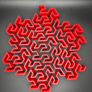 May include: A red 3D printed snowflake-shaped maze with intricate pathways and a complex design.