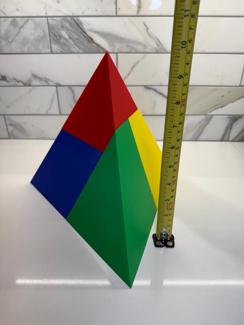 May include: A four-sided pyramid made of four different colored pieces of foam. The pyramid is red, blue, green, and yellow. The pyramid is about 7 inches tall.