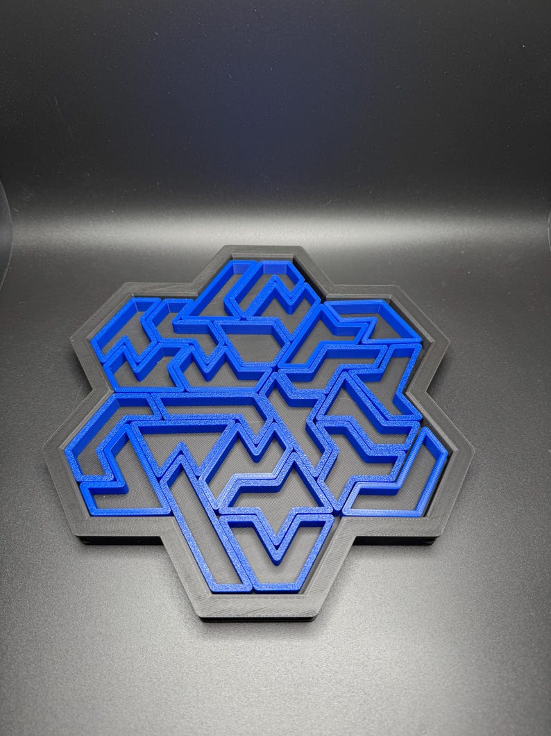May include: A blue plastic maze puzzle in the shape of a hexagon. The maze is made up of a series of interlocking lines and curves.