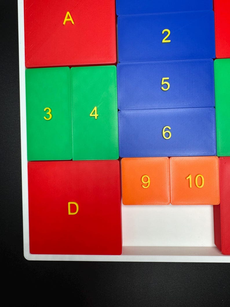 K&ouml;nnte beinhalten: Nahaufnahme eines bunten Puzzles mit roten, gr&uuml;nen, blauen und orangen Kacheln. Die Kacheln haben Buchstaben und Zahlen darauf, darunter A, 3, 4, 2, 5, 6, 9, 10 und D.