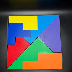 May include: A colorful wooden puzzle with seven pieces. The pieces are in the shapes of squares, rectangles, and triangles. The colors are red, blue, green, yellow, and purple.